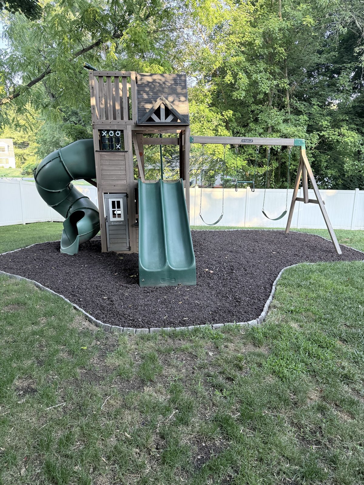 Play set on a new rubber mulch bed with paver border