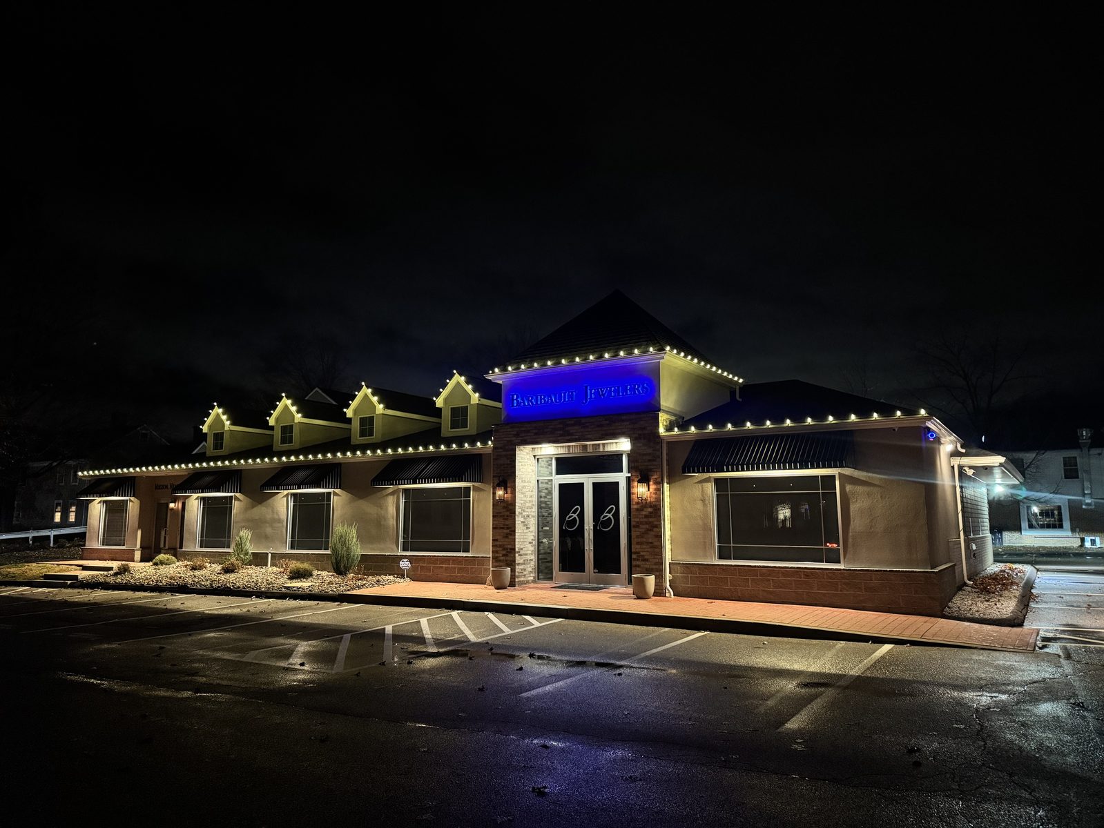 Barbault Jewelers storefront outlined in warm white C9 lights at night
