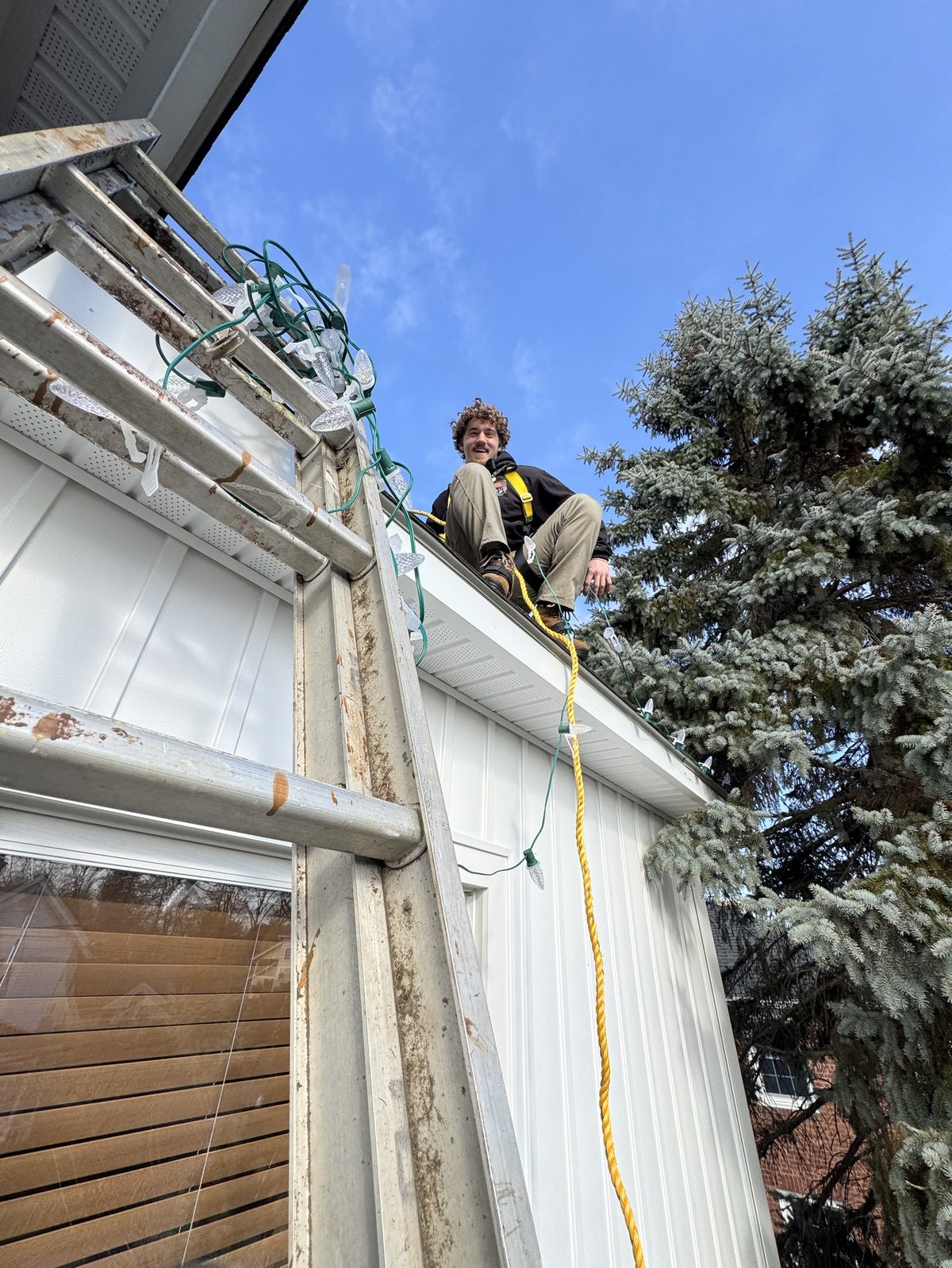 Crew member on a roof installing C9 lights