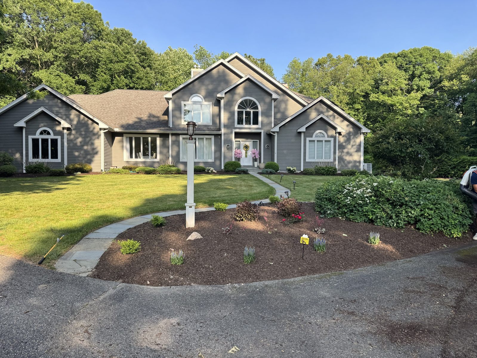 Fresh mulch bed with new perennials and shrubs along a curved bluestone walkway