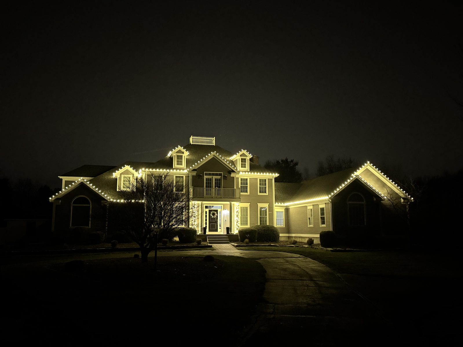 Large home lit along every roofline and dormer