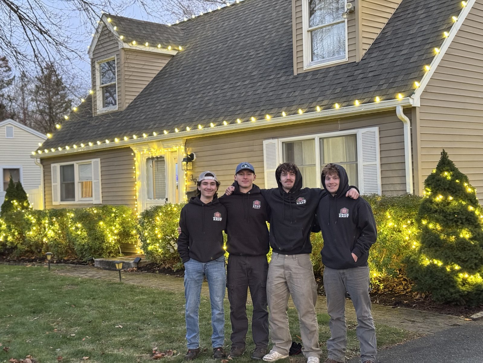 The True East crew in front of a home they lit for the holidays